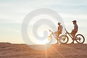 Taking in the view while out cycling. Full length shot of two young male athletes mountain biking in the wilderness.