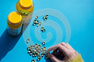 Taking vitamine medicine pills over blue background.