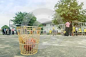 The takraws in the plastic basket on the cement floor beside the field is used for students to practice in the physical education