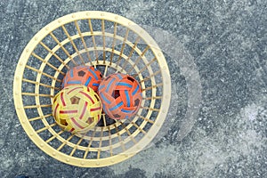 The takraws in the plastic basket on the cement floor beside the field is used for students to practice in the physical education