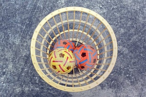 The takraws in the plastic basket on the cement floor beside the field is used for students to practice in the physical education