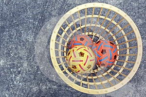 The takraws in the plastic basket on the cement floor beside the field is used for students to practice in the physical education