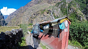 Tal - A man walking along the wall with prayer wheels