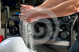 Talc in male hands in gym