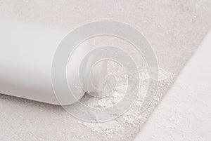 Talcum powder on a soft white towel background
