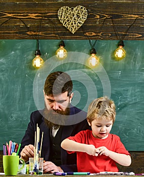 Talent and creativity concept. Child and teacher on busy faces painting, drawing. Teacher with beard, father and little