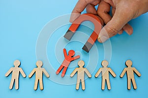 Talent employee attracting and recruitment. Red figure and magnet. photo