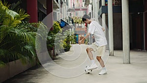 Talented Asian Teenager Guy Running and Kicking Soccer Ball Outside.