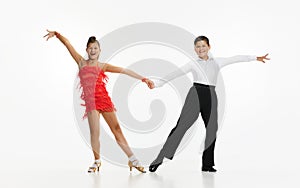 Talented, beautiful, artistic children, boy and girl in stage costumes dancing retro style dance against white studio