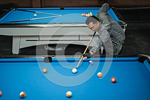 talented billiard player poking the white ball during the game