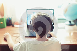 Talented gamer left handed boy playing on laptop photo