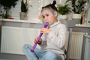 A talented girl plays the flute. Online learning to play musical instruments.