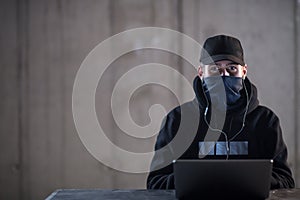 Talented hacker using laptop computer while working in dark office