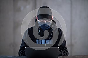 Talented hacker using laptop computer while working in dark office