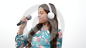 talented happy teen girl singer listen music in headphones and sing karaoke in microphone, singing.