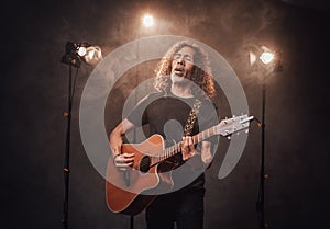 Talented hispanic musician in black t-shirt playing guitar