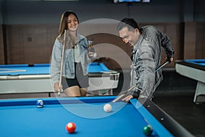 talented male pool player poking the white ball from his back