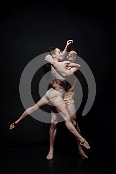 Talented performers dancing isolated in black background