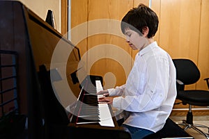 Talented teenage musician creates music and song, performs on the pianoforte, composes a melody