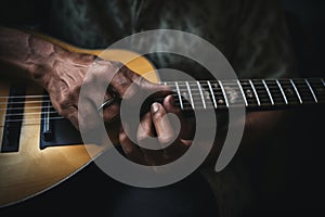 Talented unrecognizable male artist African-American musician close up male hands playing guitar fingers touching