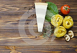 talian food ingredients: pasta, tomato, spinach, pepper, porcini on wooden background