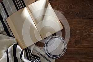 Talite, kippah, torah on a wooden table. Space for text