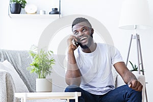 Talkative african guy talking on phone with friends