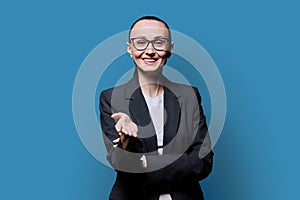 Talking business middle aged woman looking at camera on blue studio background