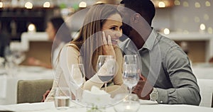 Talking, conversation or interracial couple in restaurant to celebrate marriage anniversary at dinner at night. Whisper