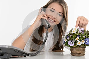 Talking with friend. Cheerful teenage girl talking at phone and