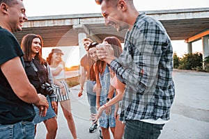 Talking and laughing. Group of young cheerful friends having fun together. Party outdoors