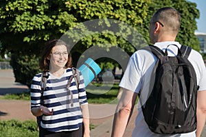 Talking middle-aged man and woman, couple walking along park road