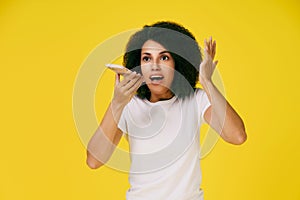 Talking on the phone using speaker or recording voice message young african american woman with afro hair gesturing with