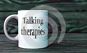 TALKING THERAPIES - the words on a white cup on a dark background