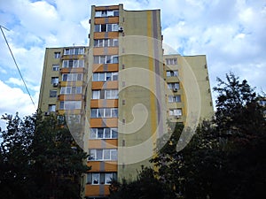Tall apartment building of the late socialism era. Yellow facade, balconies and loggias, residential condition. photo