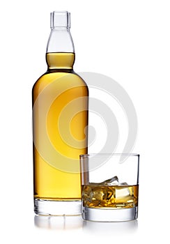 A tall bottle of golden whisky, with no label or branding, and a classic glass of whisky and ice, isolated on white