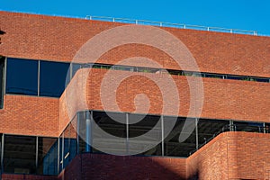 Tall brick building facade with shade on exterior in the business district of the downtown city in daylight