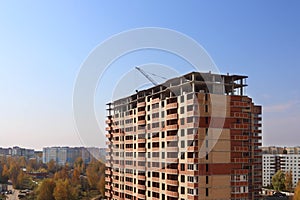 Tall brick building under construction at autumn day