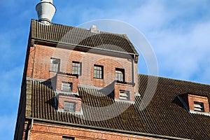 Tall brick house roof on a clear blue sky background