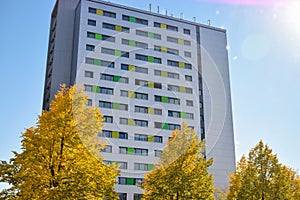 Tall building with colored windows and yellow trees in Europe