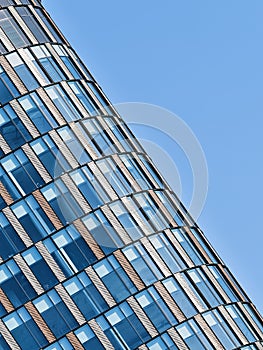 Tall building full of glass windows in abstract architecture at an angle outdoors