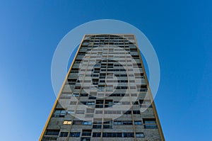 Tall building with windows against blue sky on the background