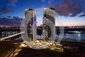 Tall buildings near the river at night in Kyiv