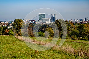 Tall buildings, tree and meadow in Divci Hrady recreation area in autumn sunny day, Prague