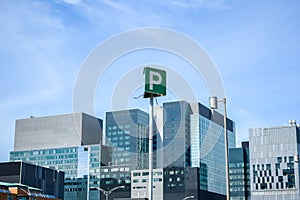 The tall business skyscrapers and the parking sign