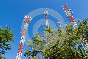 Tall cell phone and communication towers against blue sky background. High telecommunication tower on blue sky blank background. G