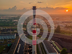 a tall chimney of a thermal power plant with a view of the city and the sunset from a drone