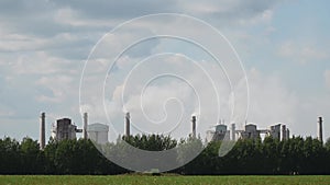 Tall chimneys of a factory with smoke rising up, polluting the atmosphere. Air pollution concept.