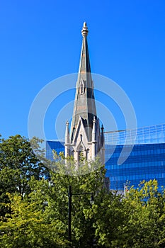 Tall church steeple against blue sky in downtown Raleigh photo