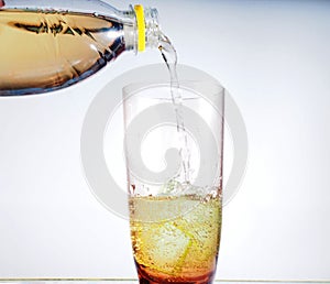 In a tall clear glass filled with carbonated beverage. photo